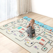 Child playing on a large play mat with road and vehicle designs on a wooden floor.
