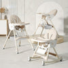 Beige baby high chair and swing set in a room with a neutral color scheme.