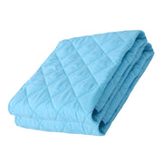 Folded light blue quilt on a white background